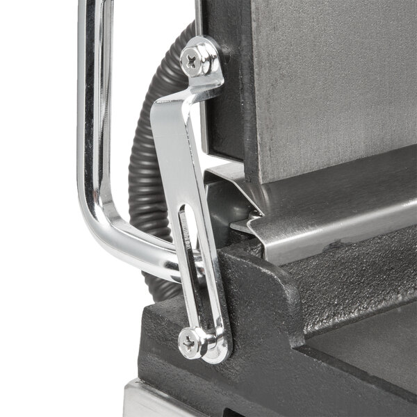 A close-up of a metal Waring sandwich grill handle bracket.