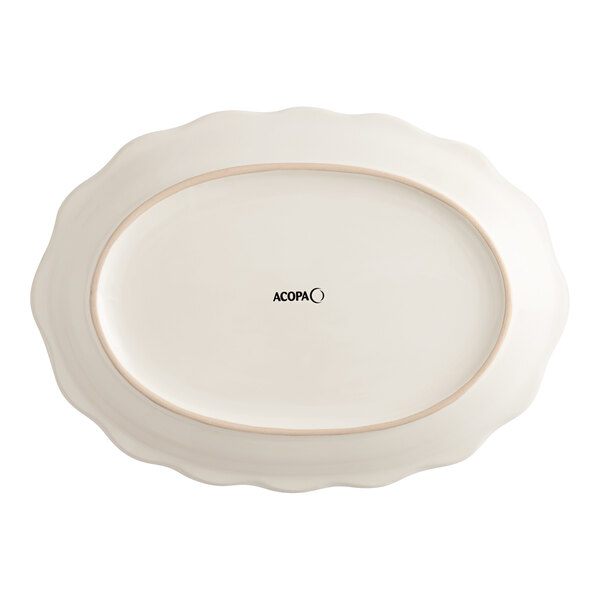 An ivory oval stoneware platter with a scalloped edge.
