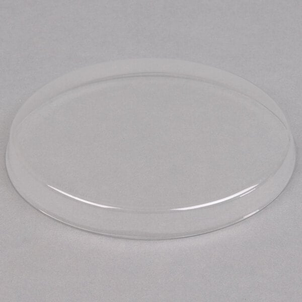 A clear plastic Mason jar lid on a white surface.