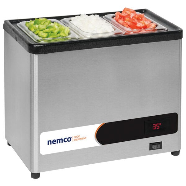 A Nemco countertop condiment chiller with three containers of vegetables on a counter.