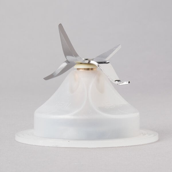 A white plastic blending assembly with a metal blade.