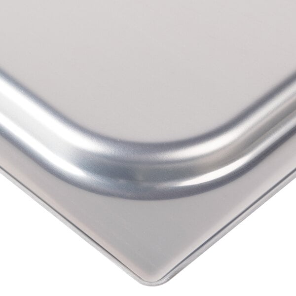 A stainless steel lid on a silver steam table pan.