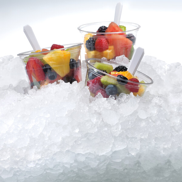 A group of fruit cups with flake ice in them.