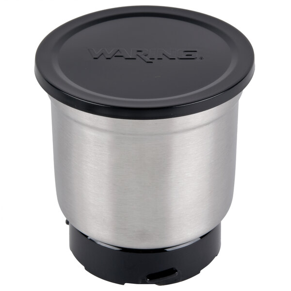 A stainless steel Waring container lid with a black center.