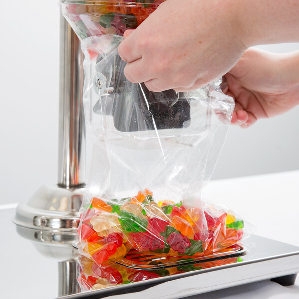 A hand opening a LK Packaging plastic candy bag.