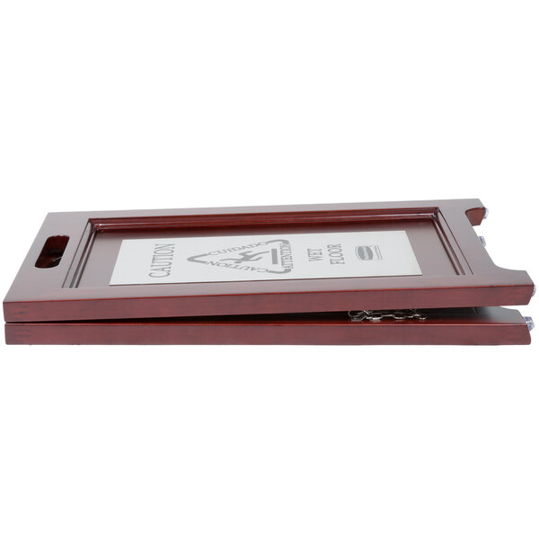 A Rubbermaid wooden wet floor sign with a white label.