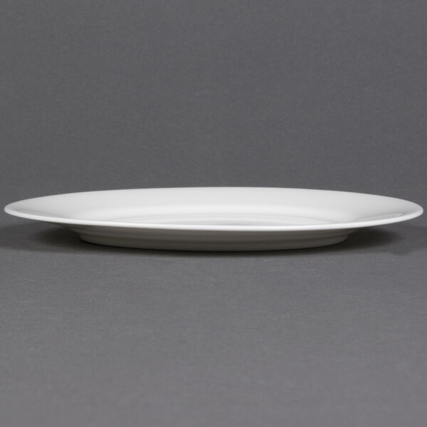 A CAC Majesty European Bone China round plate with a rim on a gray surface.