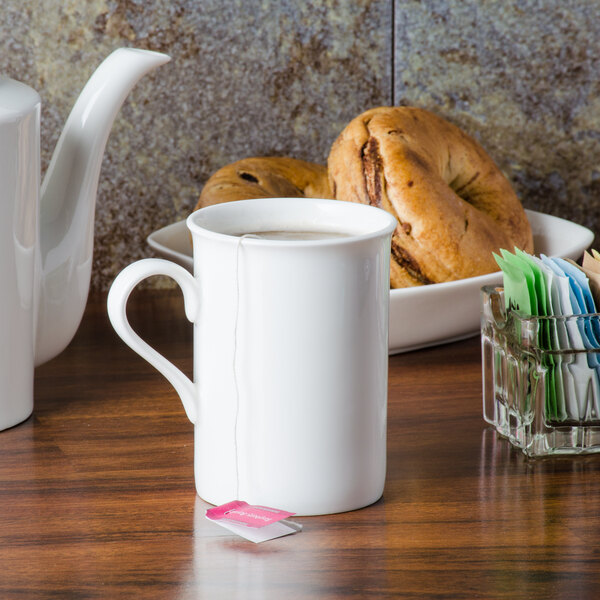 A white CAC Majesty European bone china mug with a pink tea bag in it.