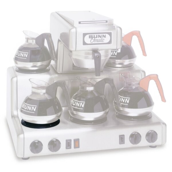 A Bunn coffee maker with a black and silver warmer assembly with four coffee pots on top.