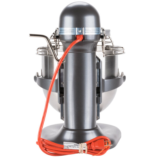 A dark grey KitchenAid commercial mixer with a red cord.