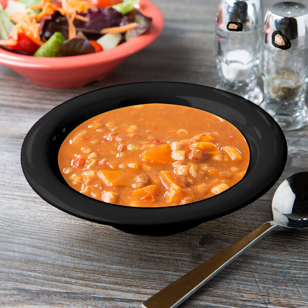 A black GET Elegance bowl with soup and a spoon on a table.