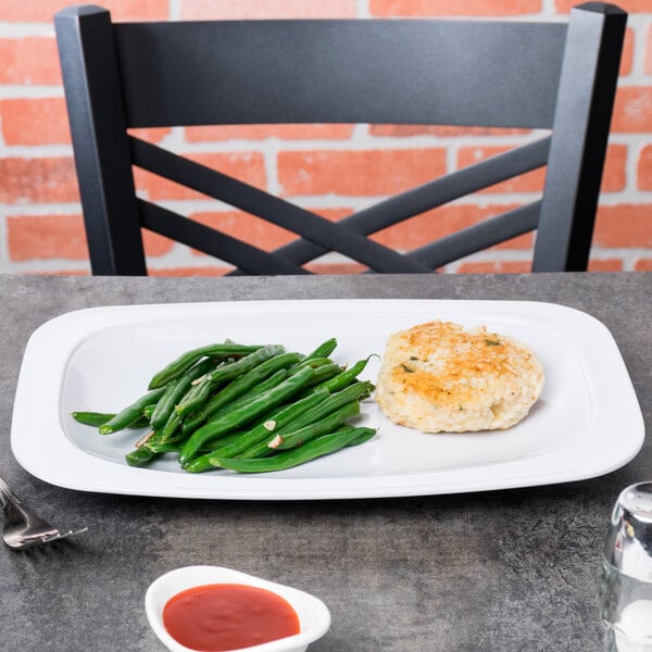 A white oval platter with fish and green beans on it.