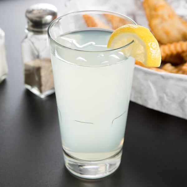 A Libbey stackable beverage glass with a lemon wedge in the liquid.