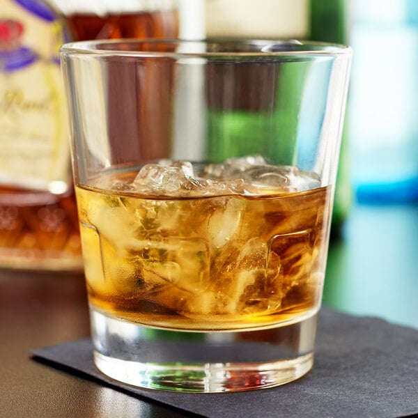 A Libbey stackable double old fashioned glass with ice and amber liquid.