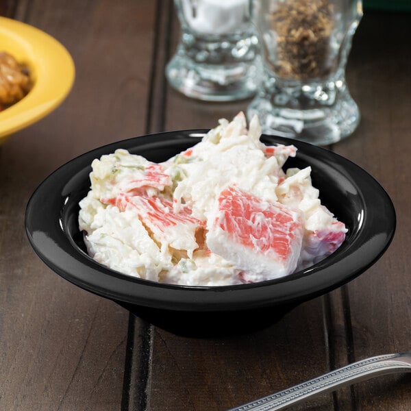 A black melamine bowl filled with crab salad.