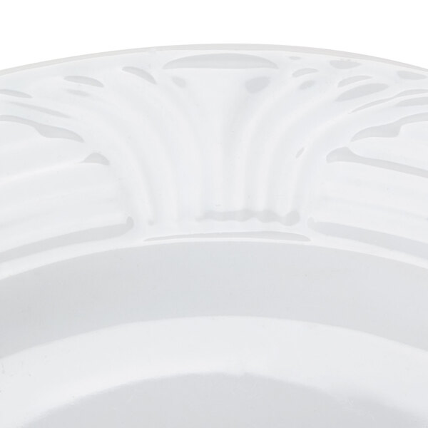 A close up of a CAC white porcelain plate with a decorative design.