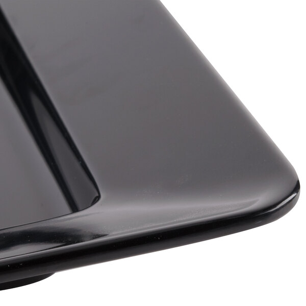 A close up of a black GET Milano melamine square plate.