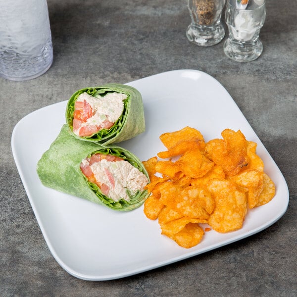 A white square coupe plate with potato chips on it.