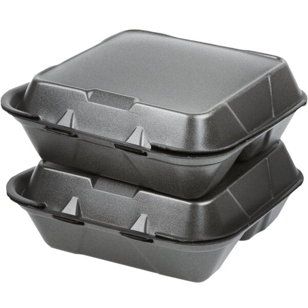 A stack of Genpak black 3-compartment foam containers with lids.