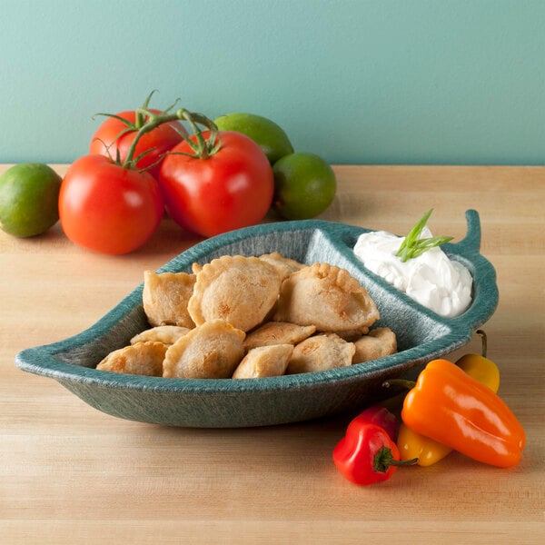 A HS Inc. Jalapeno Peppertizer bowl filled with food next to tomatoes and peppers.