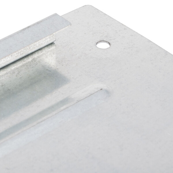 A close-up of a metal bottom cover plate with a hole in it.