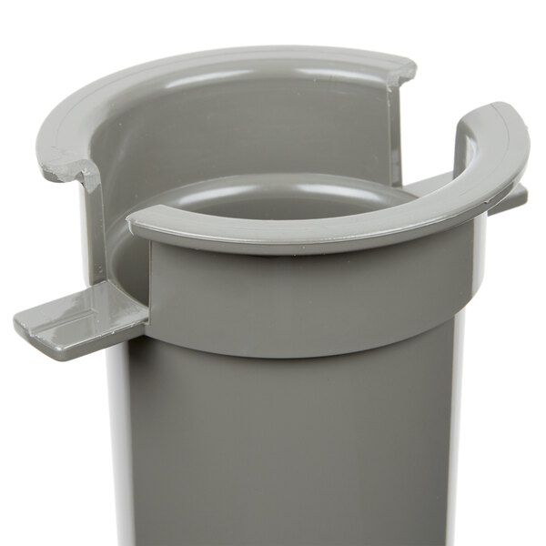 A small gray plastic pusher with a hole.