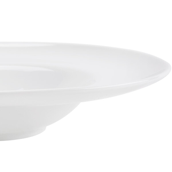 A close-up of a CAC Paris bone white porcelain soup bowl with a rim.