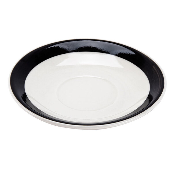 A black saucer with a white rim.