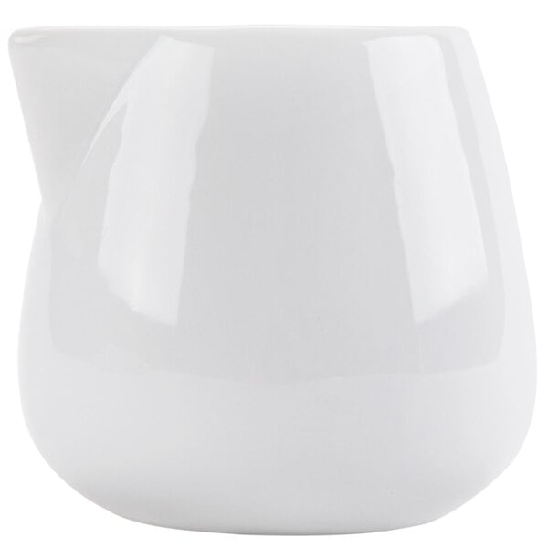 A white ceramic CAC creamer with a curved edge and handle.