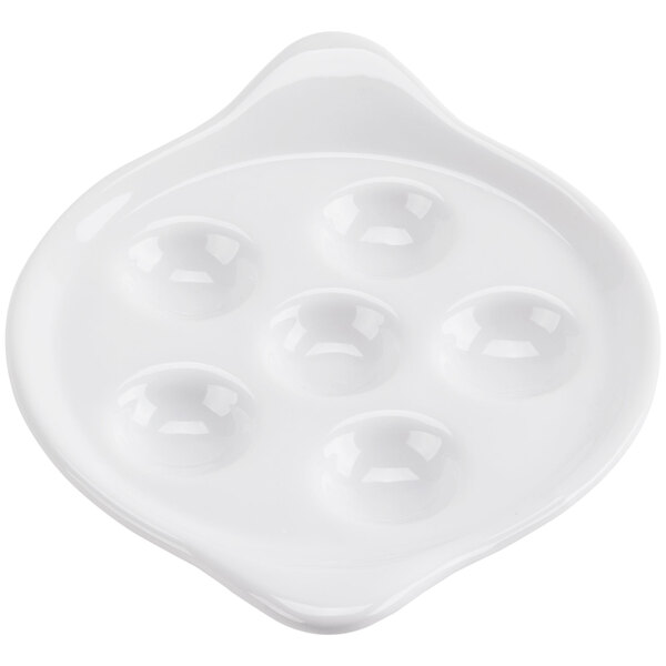 A bright white porcelain escargot dish with six holes in it.