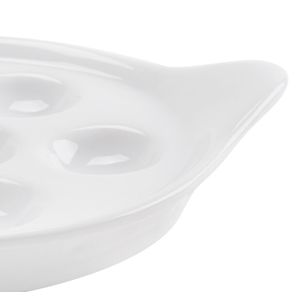 A close up of a CAC porcelain escargot dish with six holes.