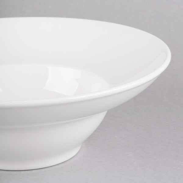 A Homer Laughlin white china bowl with a white rim on a gray surface.