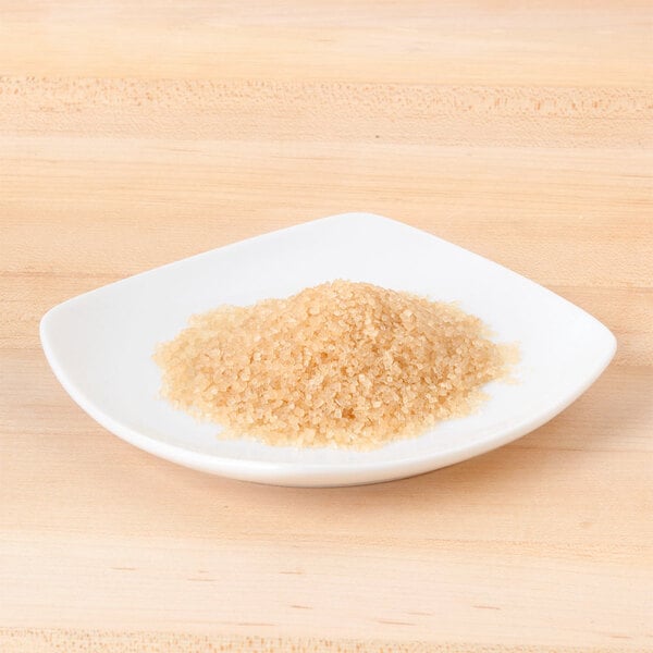 A small plate of Sugar In The Raw brown crystals.