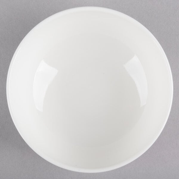 A Homer Laughlin Ameriwhite Alexa bowl with a white rim on a gray surface.
