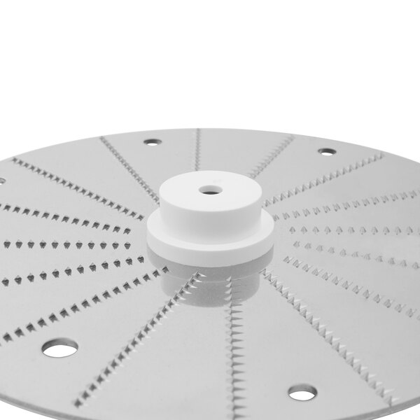 A Robot Coupe horseradish grating disc, a circular metal disc with holes in it.