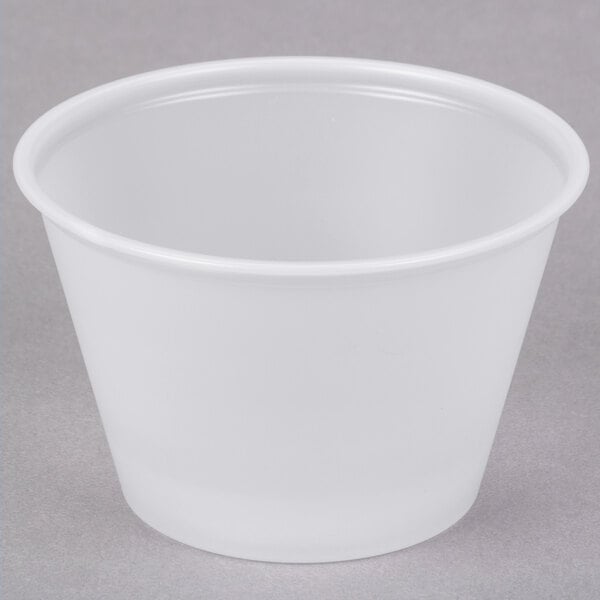 A translucent Solo polystyrene portion cup on a gray surface.
