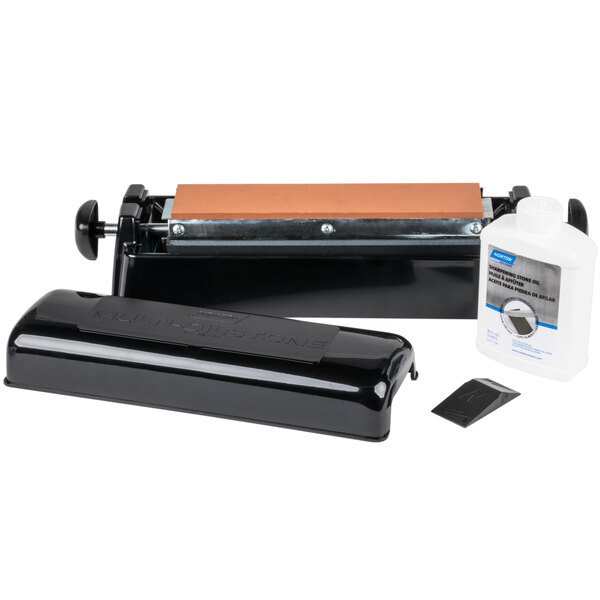 A black Victorinox Norton Multi-Oilstone Honing System on a metal surface with a white bottle of oil.