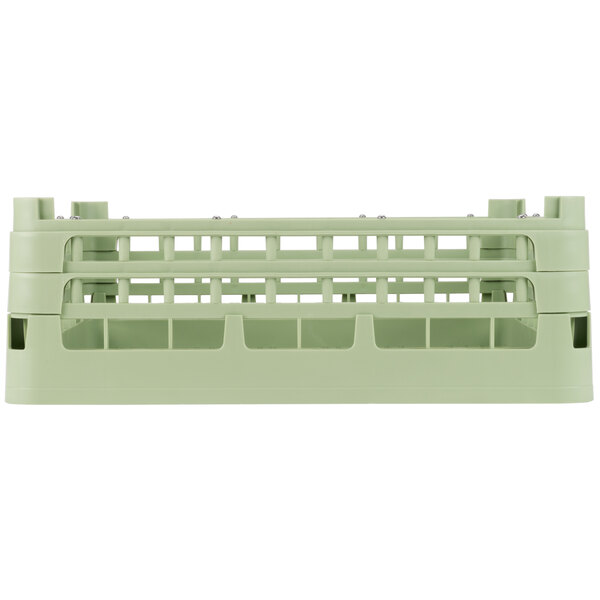 A Vollrath green plastic dish rack with two compartments.