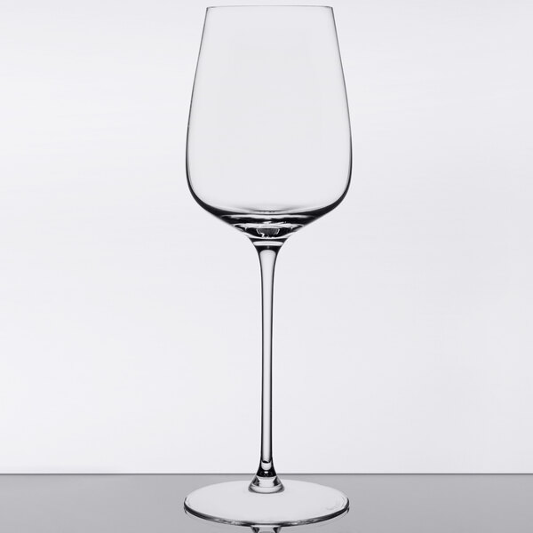 A clear Spiegelau Willsberger white wine glass on a table with a reflection.