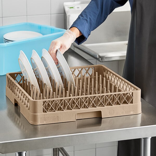 A woman using a Vollrath TR14 Traex plate rack to hold plates.