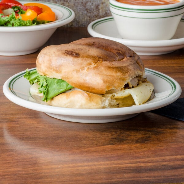 A Homer Laughlin green banded plate with a sandwich and salad.