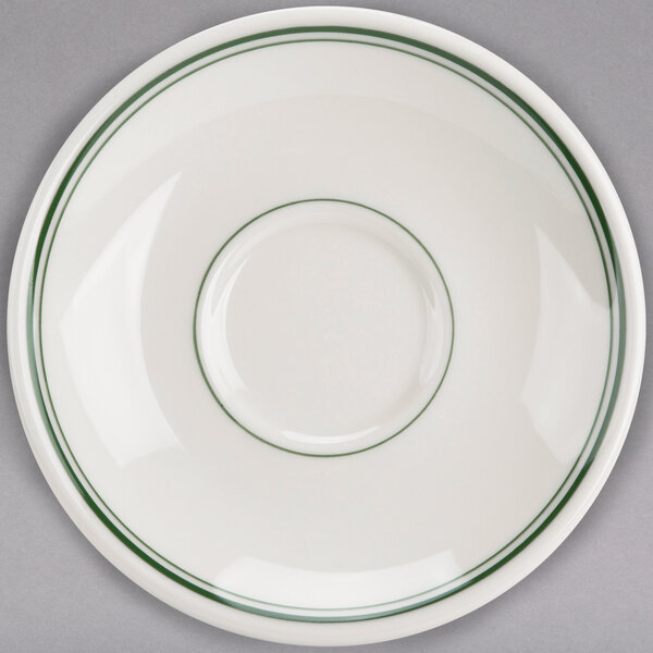 A white saucer with a green rim.