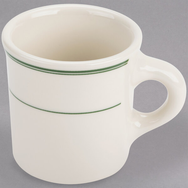 A white mug with green stripes around the rim.