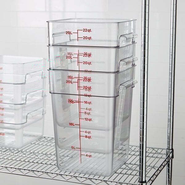 A metal rack with a stack of clear Cambro CamSquares food storage containers.