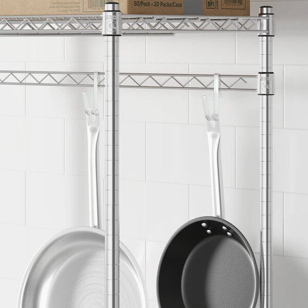 A Regency chrome hanger rail holding pans and pots.