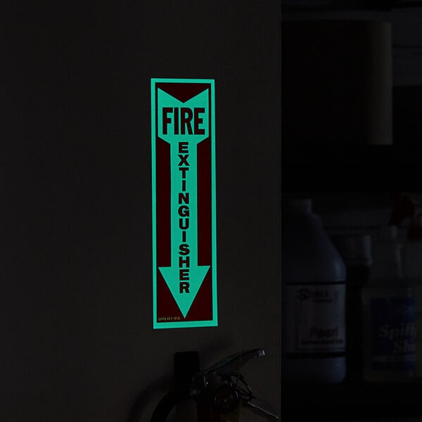 A Buckeye fire extinguisher adhesive label glowing in the dark on a wall.