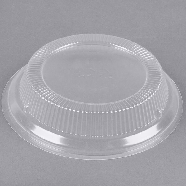 A clear plastic lid with a plastic rim on a clear plastic container.