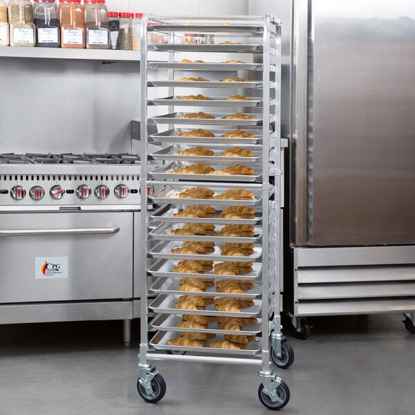 A tall, metal sheet pan rack on wheels holding multiple trays of baked goods in a commercial kitchen setting.