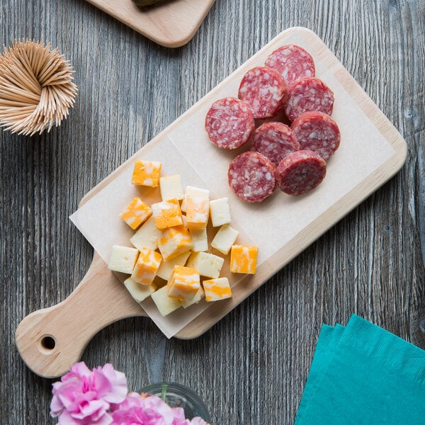 A cutting board with cheese and meat on it.