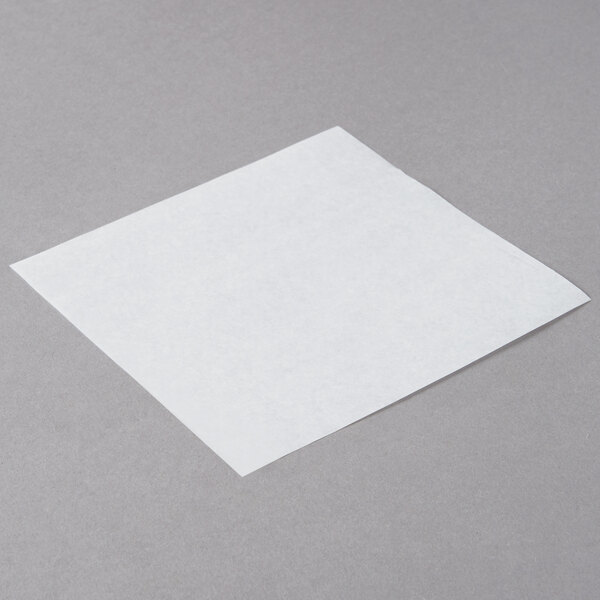 Choice white square patty paper on a gray surface.